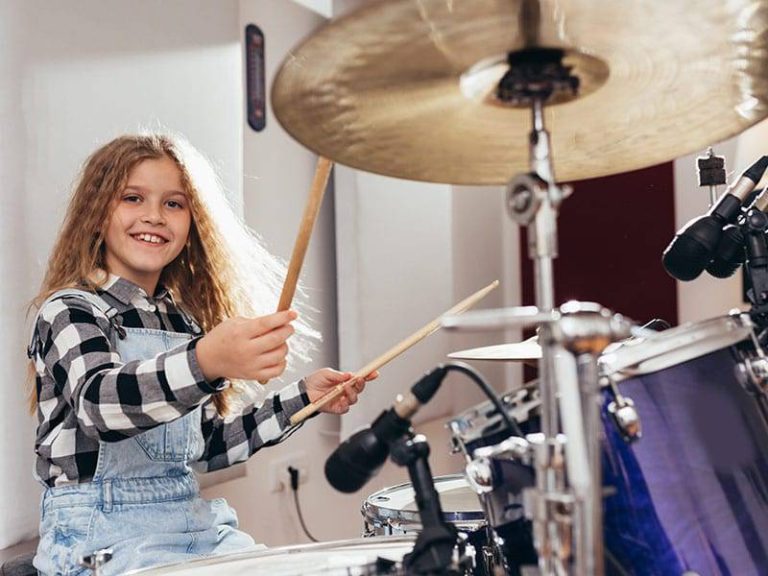 YoungGirlPlayingDrumsHappyandSmilingCover